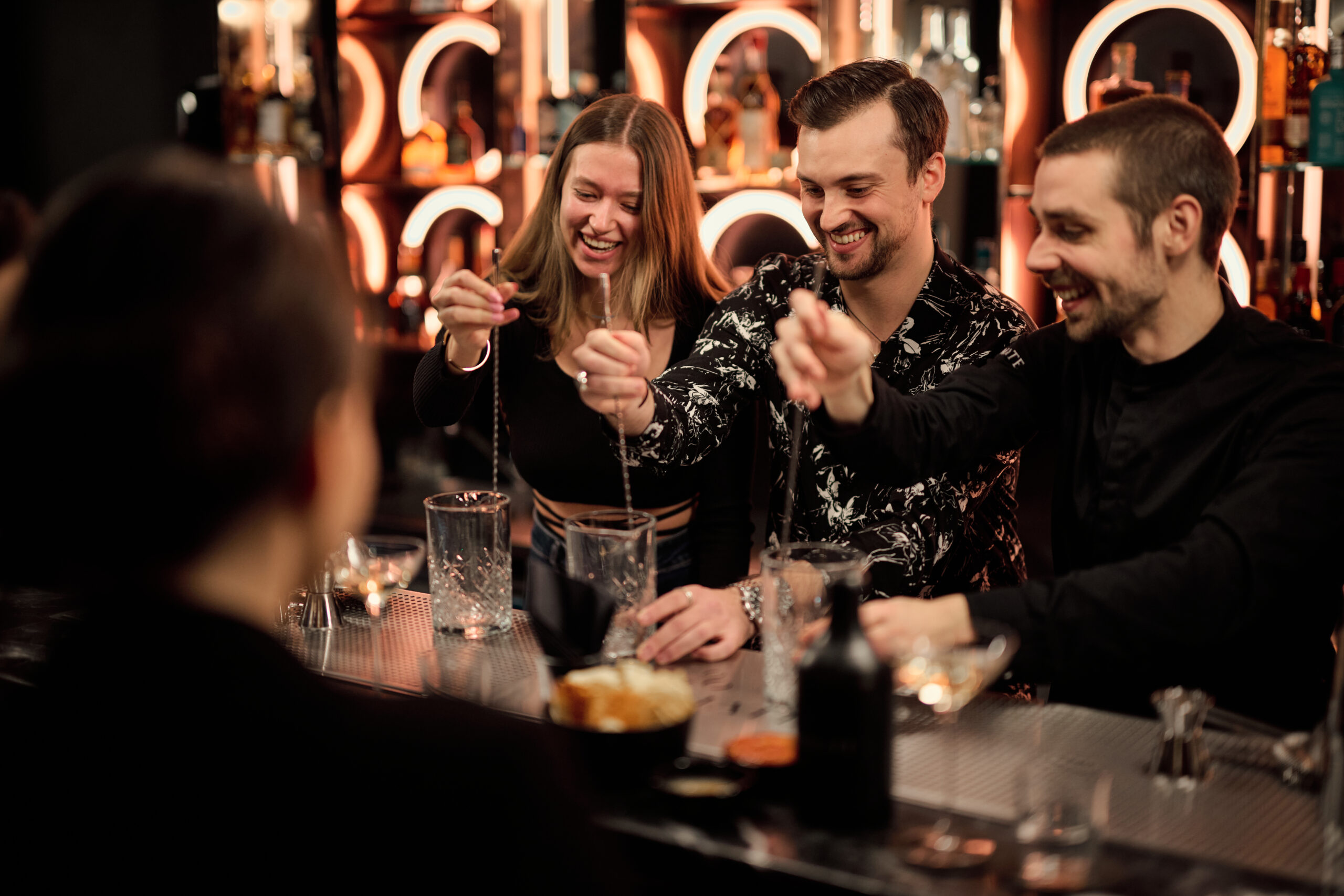 Firmenevent Cocktailkurs Cocktails Rühren mit zwei Frauen und einem mann